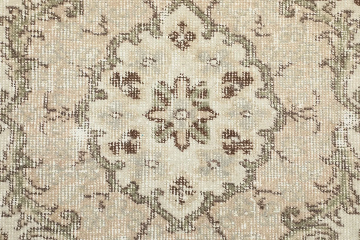 Extreme close-up of the rug's low pile, showing the hand-knotted wool texture and color variations.