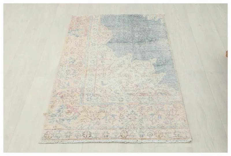 Full top view of the 2x4 blue and beige vintage Anatolian rug on a white background