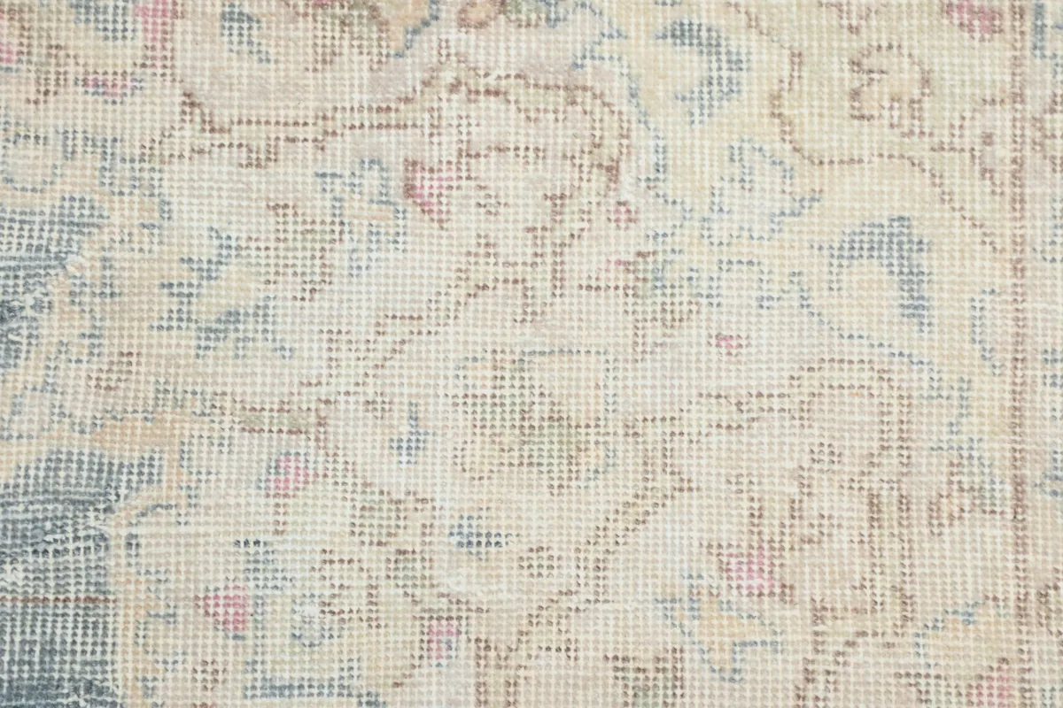 Macro detail of the low wool pile, showing the hand-knotted texture and intricate floral patterns