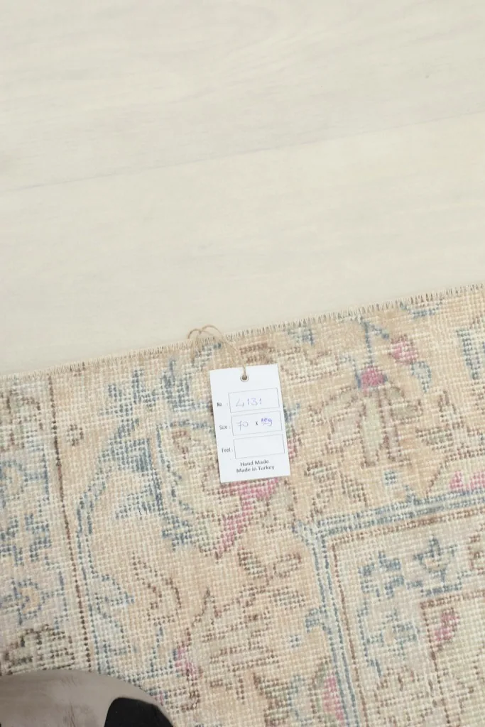 Close-up of the rug's surface with a small tag, showing the detailed weave and colors