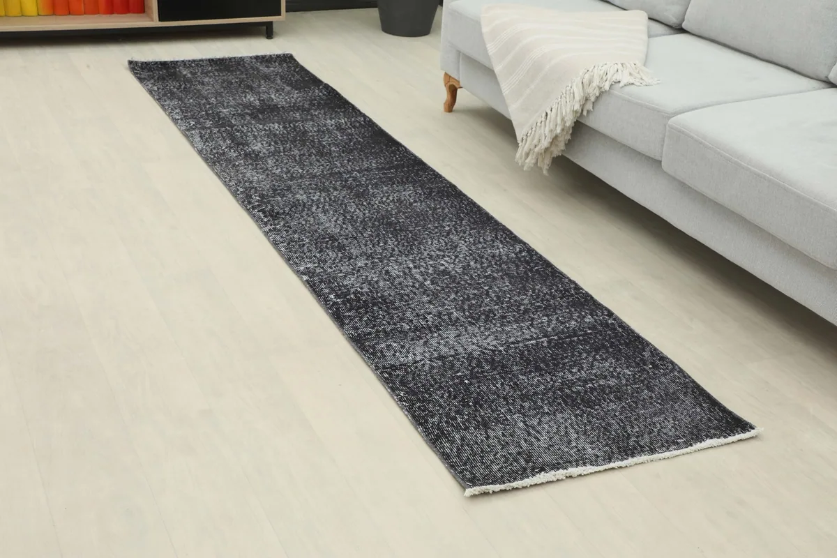 Angled view of the runner rug extending from a couch in a room setting