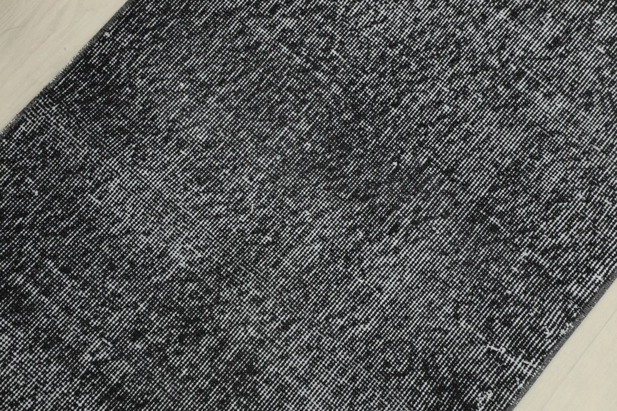 Detailed view of the low pile and textured surface of the vintage rug