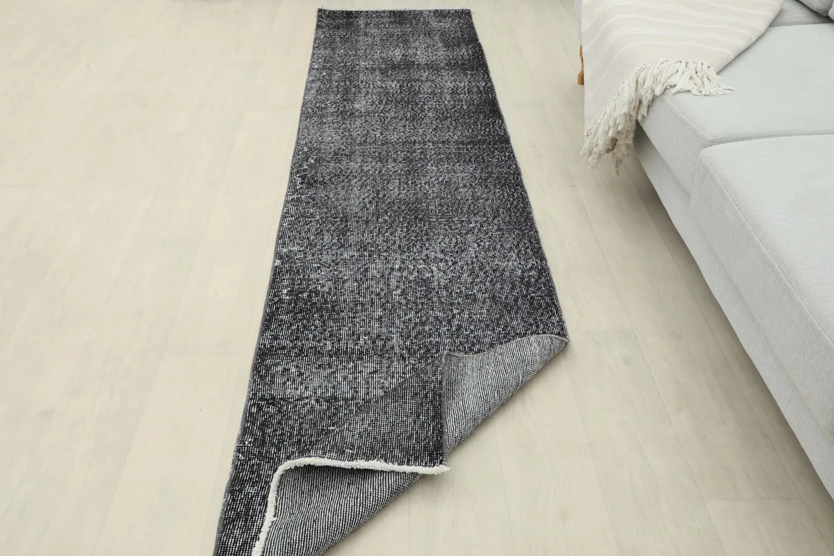 Runner rug with a corner folded back, showing the thickness and construction