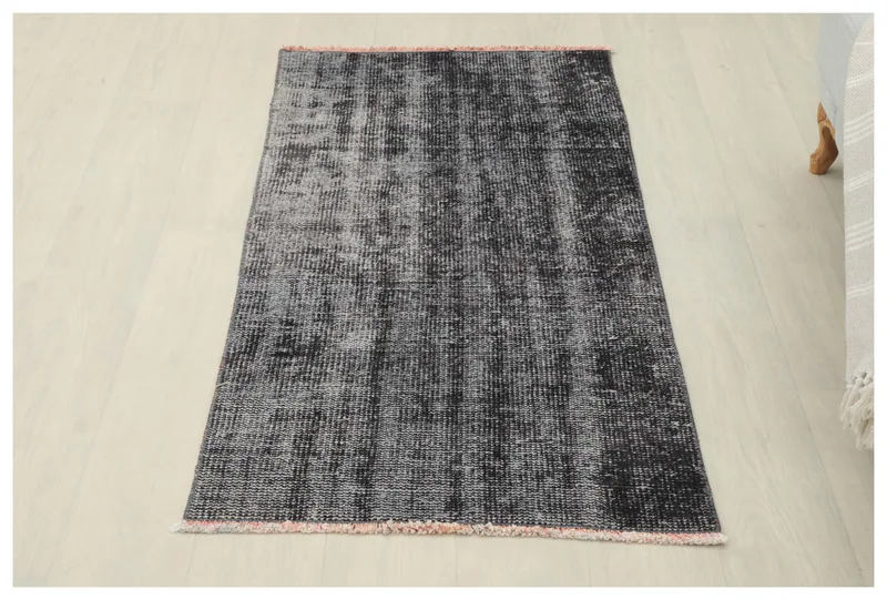 Full top view of the charcoal gray distressed area rug on a white background