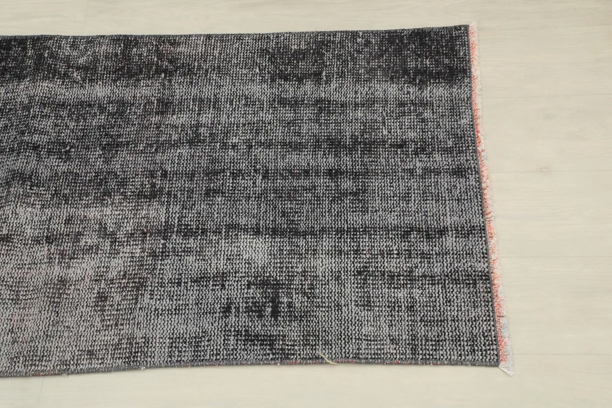Close-up of one end of the rug, highlighting the distressed charcoal and gray tones