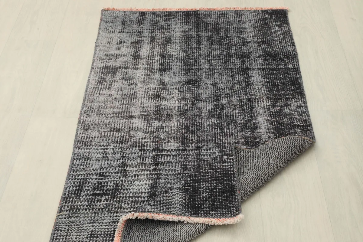 Rug partially folded, displaying the professionally cleaned condition and distressed surface