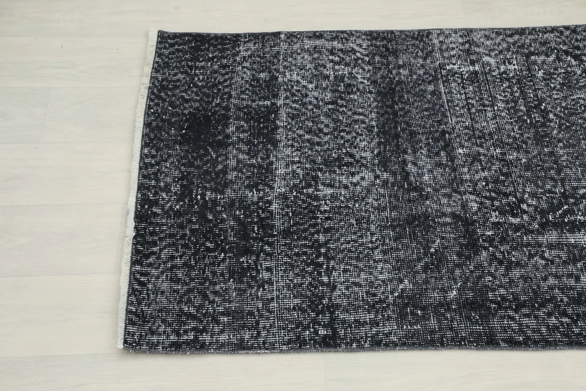 Angled view of the other end of the charcoal runner, showing the subtle variations in its distressed pattern.