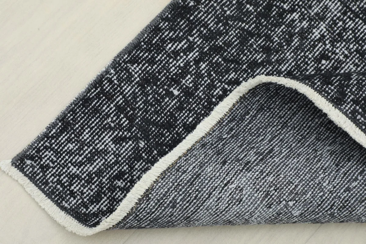 Corner of the runner folded back to show the hand-knotted wool pile on a cotton foundation.
