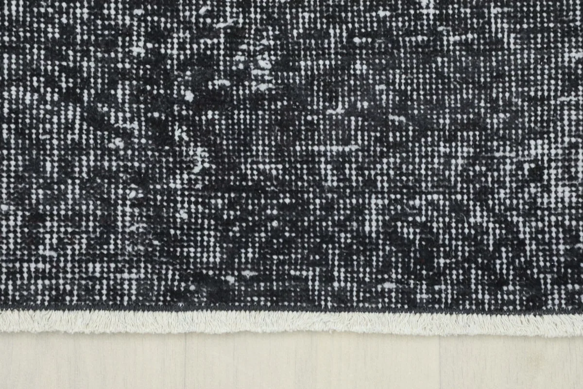 Close-up showing the edge of the charcoal runner with its short, natural ivory fringe.