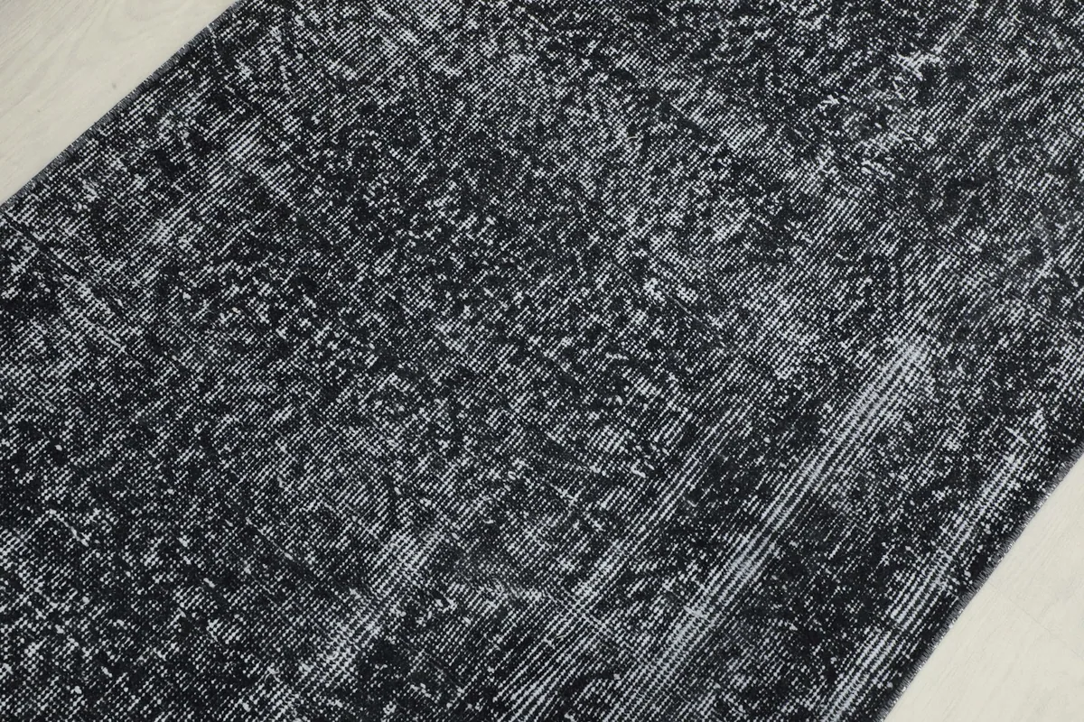 Overhead close-up of the runner's surface, revealing the charcoal and ivory woven texture.