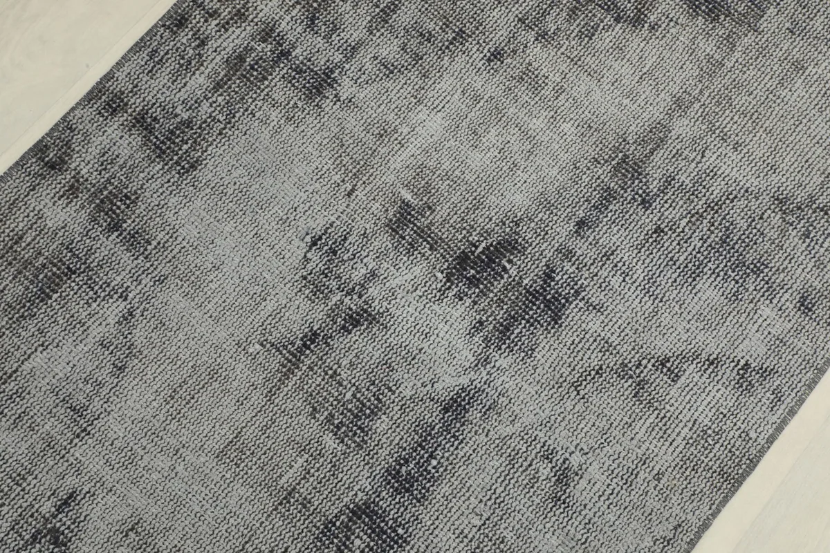 Detailed view of the distressed surface and subtle geometric weaving of the rug