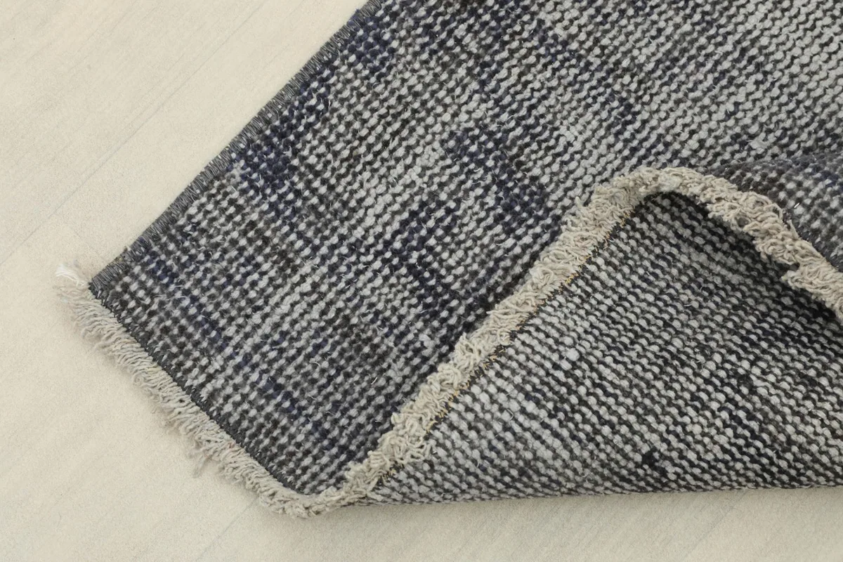 Close-up of the reverse side of the rug, revealing its tight hand-knotted backing