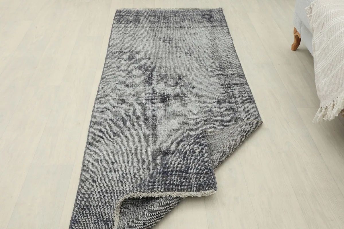 Runner rug with one end folded back, showing the cotton foundation