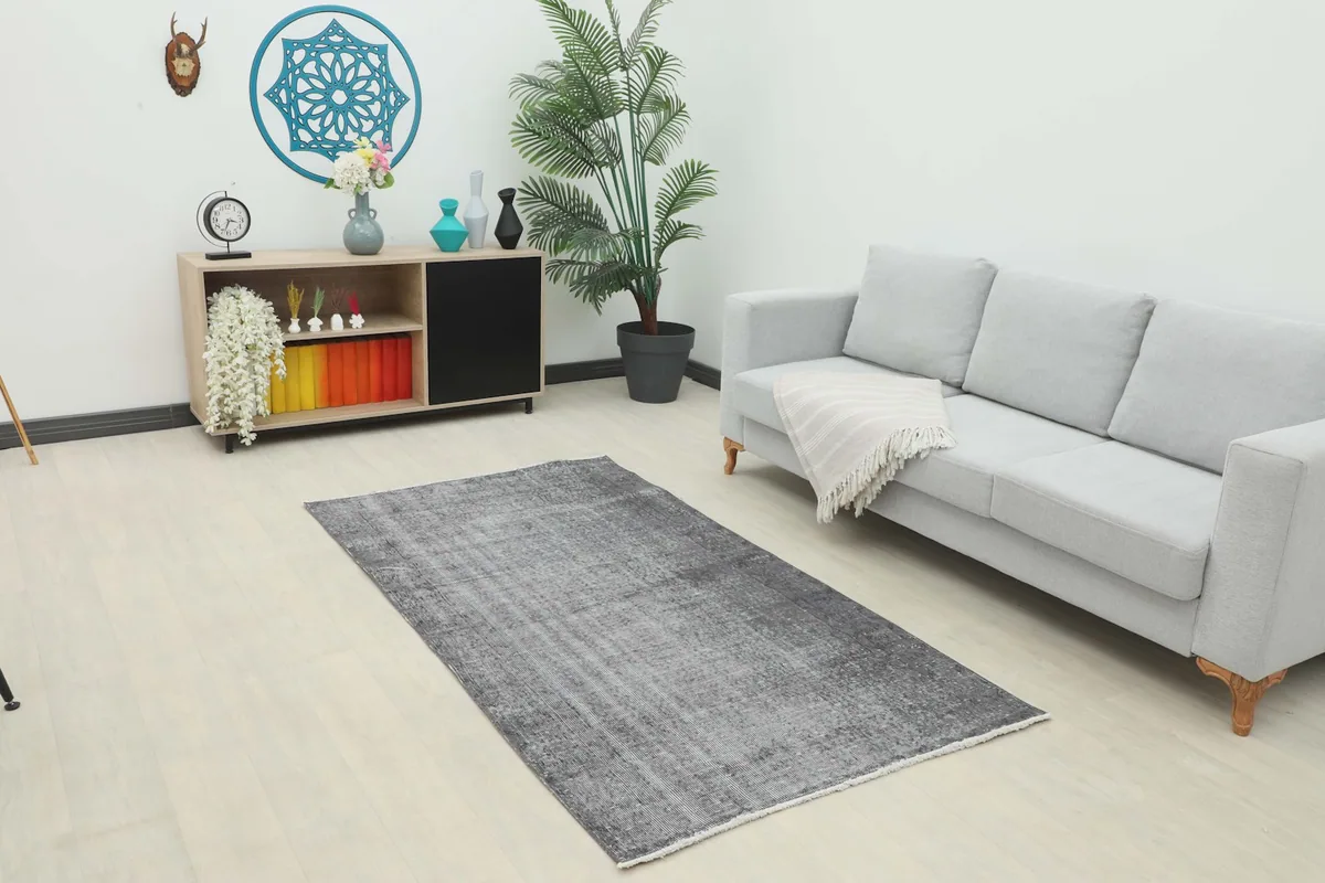 Charcoal gray rug placed in a modern living room setting with a light gray sofa