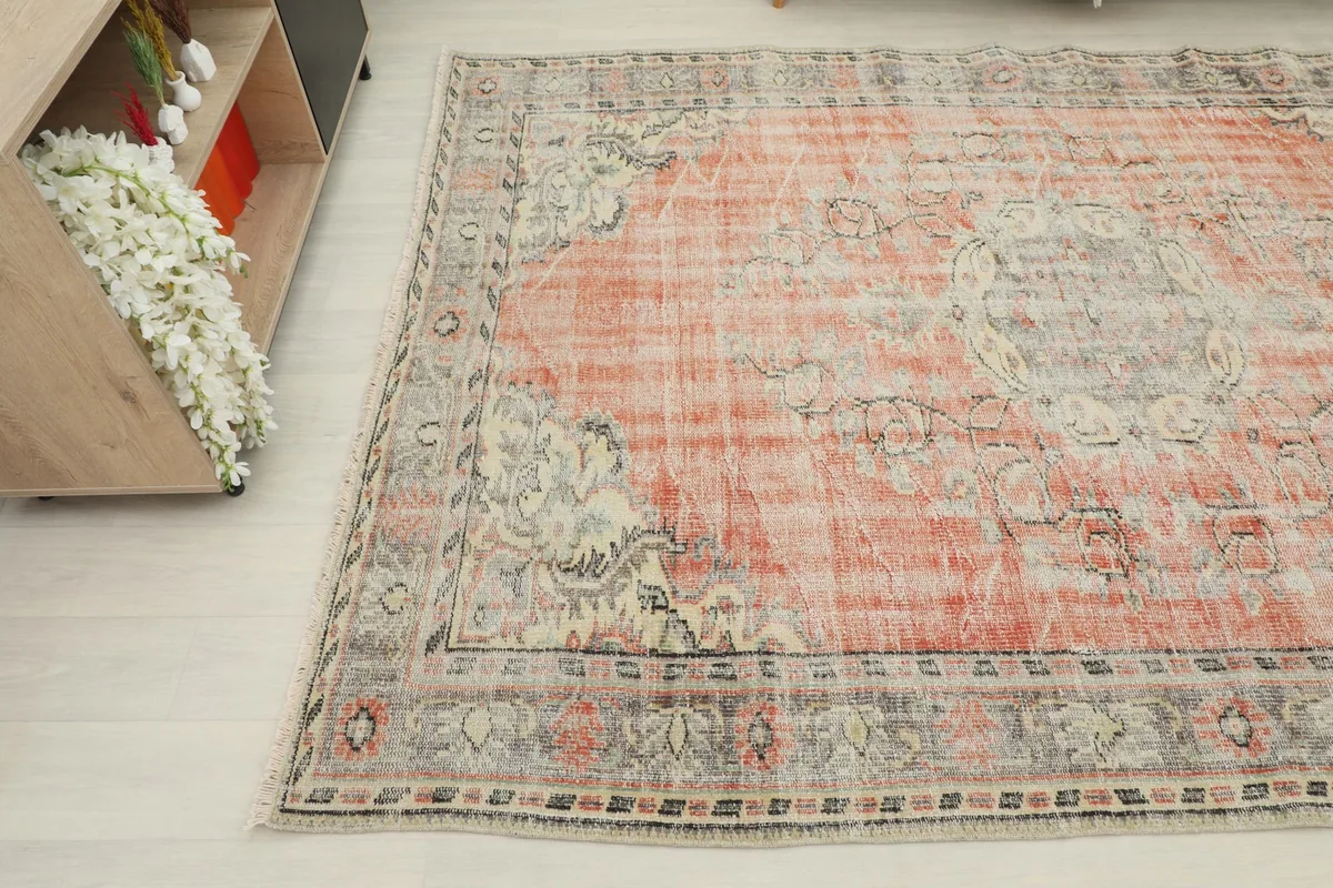 View of the vintage rug from a different angle, highlighting its distressed character.