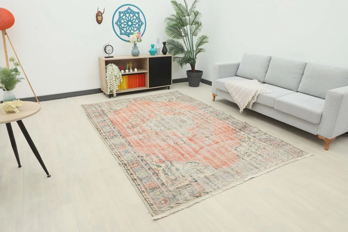 Vintage Anatolian rug displayed in a living room setting with a light gray sofa.