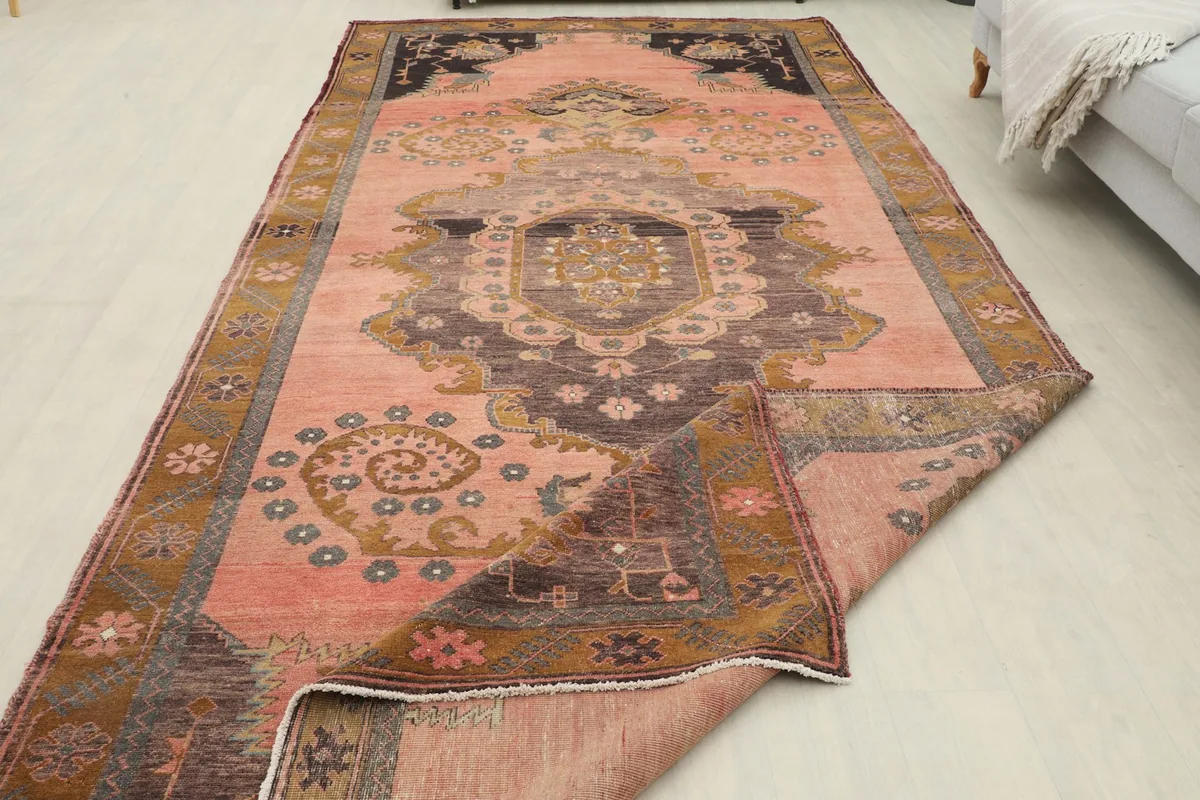 View of the rug with a corner folded, revealing the low pile texture and colors