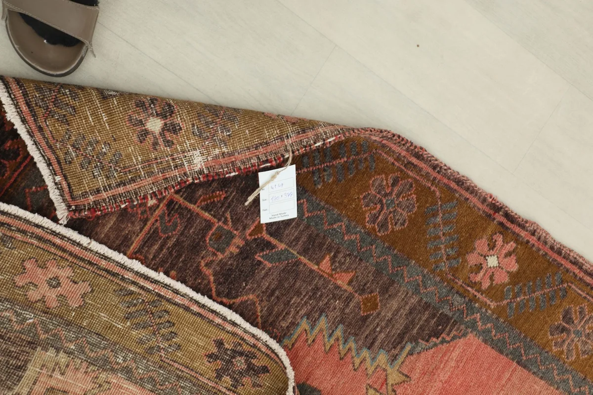 Close-up of the back of the rug, showing the hand-knotted construction and tag