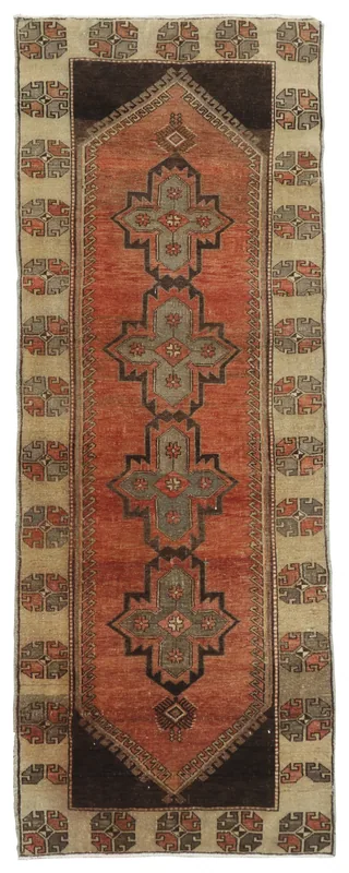Full overhead view of the 3x9 rust tribal geometric runner rug on a white background.