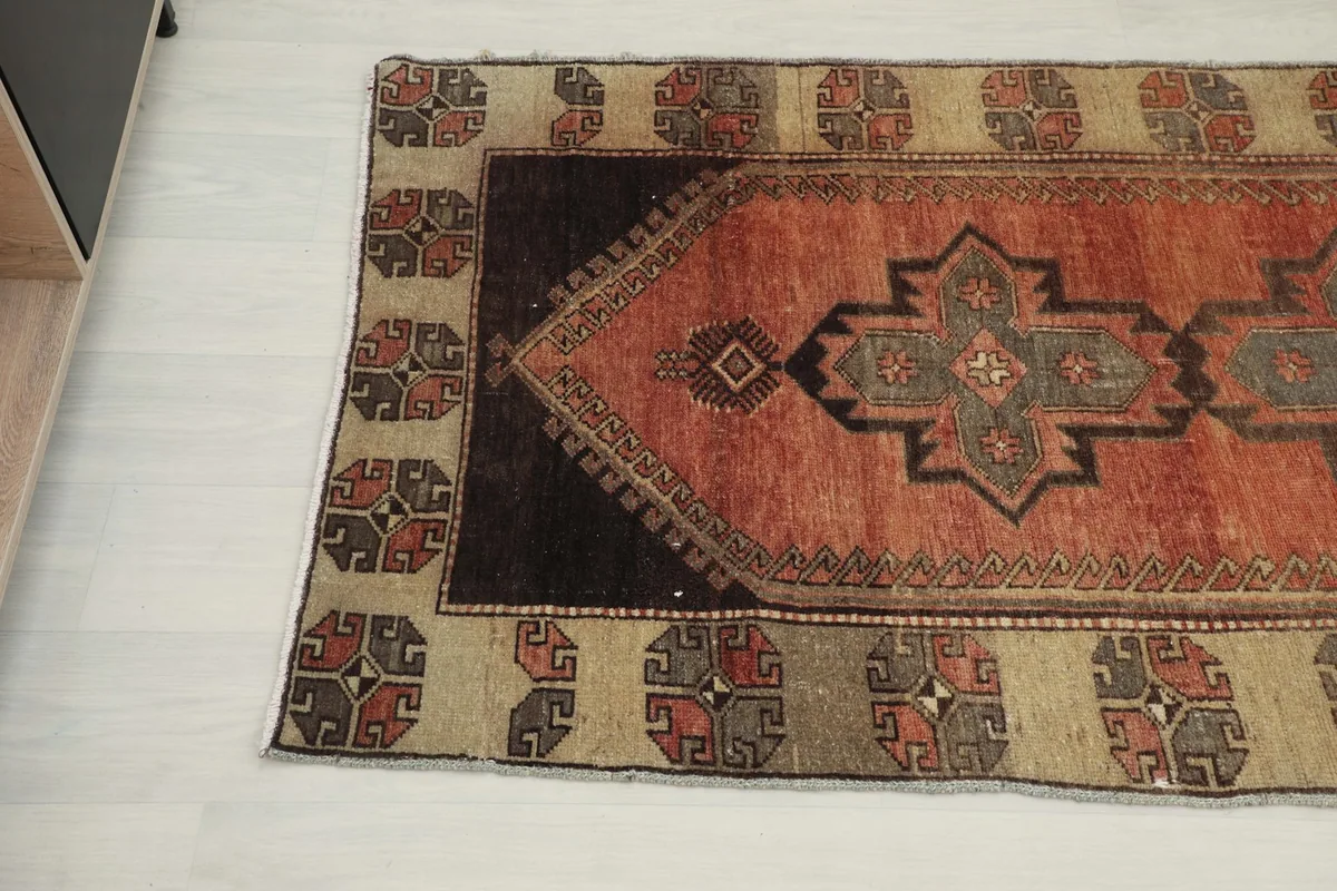 Angled view of the other end of the runner rug, highlighting the dark brown end panels and border.