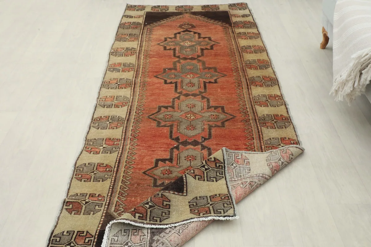 Overhead view of the rug with one end slightly folded, showing its full length and design.