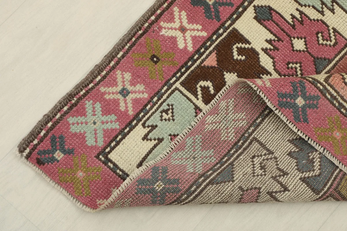 View of the rug folded to show its thickness and the reverse side of the hand-knotted cotton foundation.