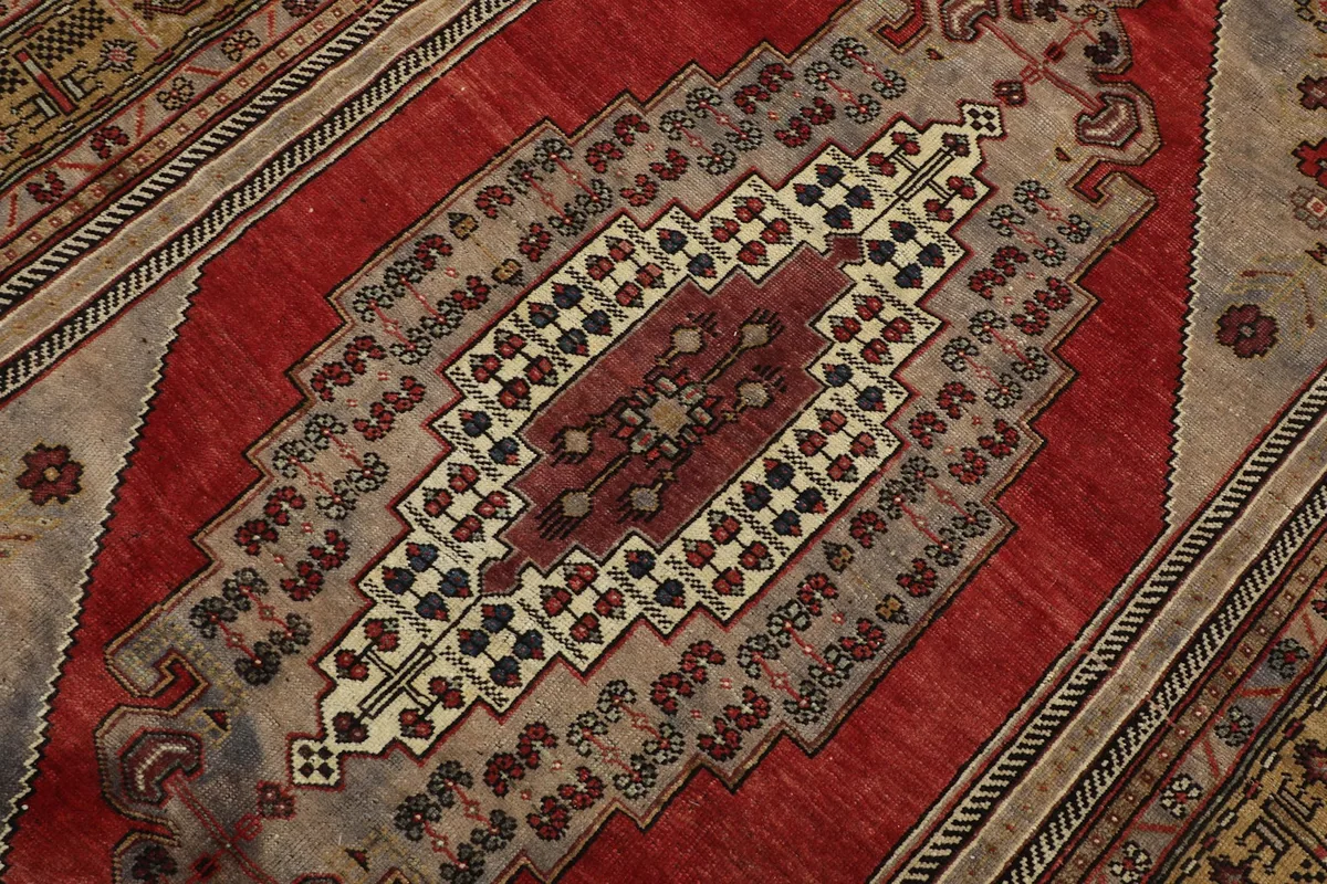 Detailed view of the central red medallion with its complex geometric and tribal motifs.