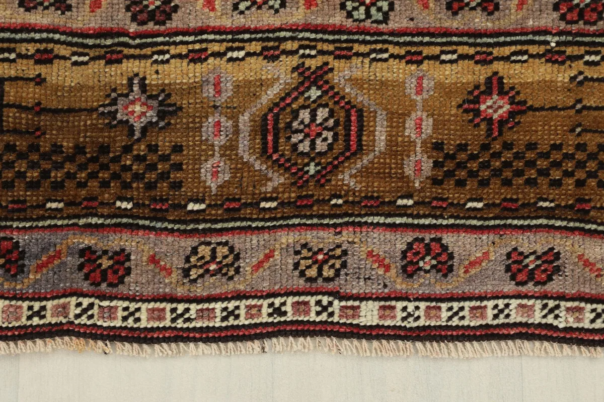 Detail of the tan and brown outer border with its distinct geometric designs and fringe.