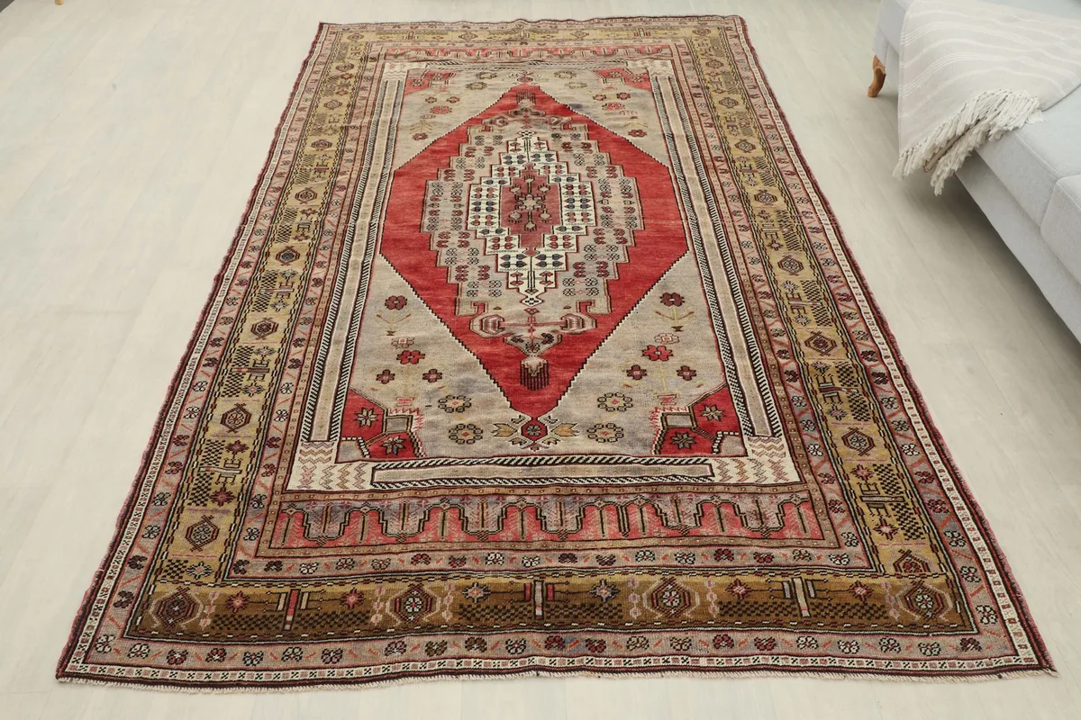 Full overhead view of the red and gray vintage rug laid out in a room, showcasing its overall design.