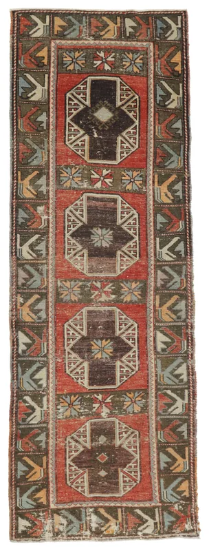 Full top view of the vintage Anatolian runner rug with a red field and geometric tribal patterns