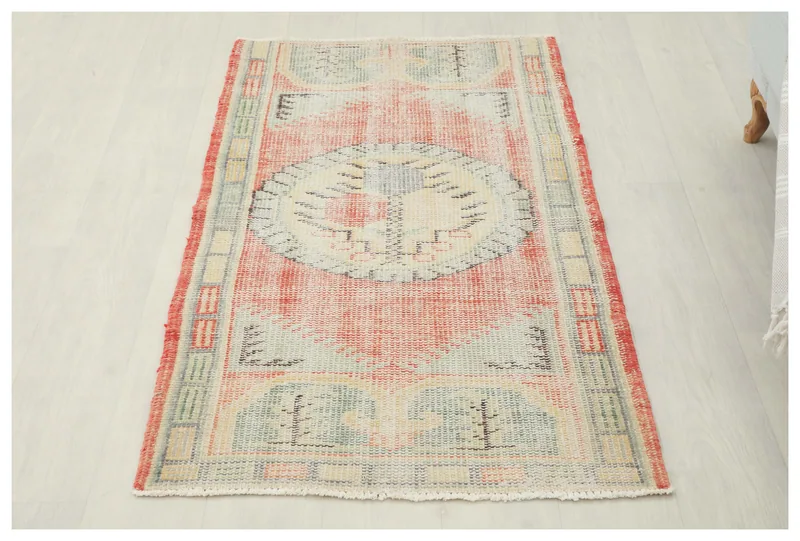 Full top view of the 2'7" x 4'8" rust and ivory geometric medallion vintage Anatolian rug on a white background.