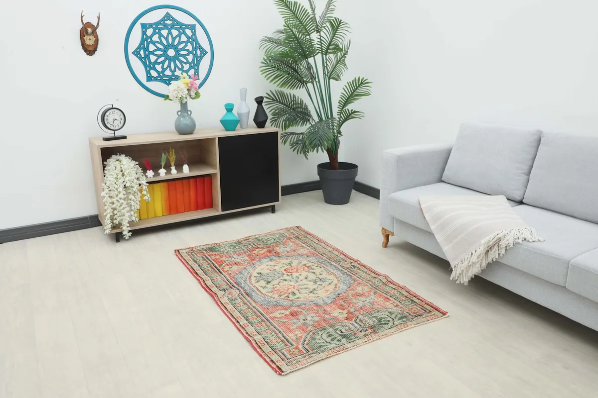 Vintage Anatolian rug displayed in a bright living room setting with a sofa and cabinet