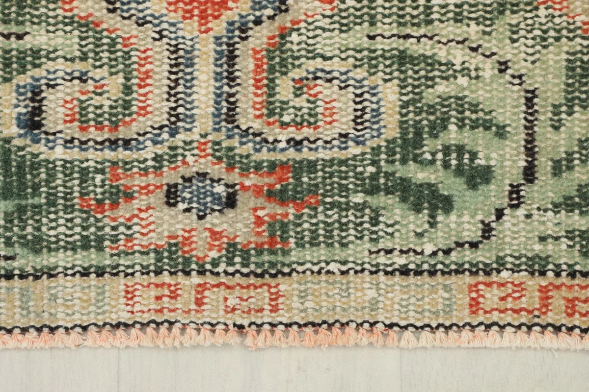 Close-up of the rug's border, revealing geometric patterns and the low pile