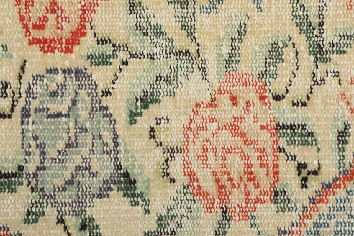 Macro shot of the rug's low wool pile and hand-knotted texture in the medallion area