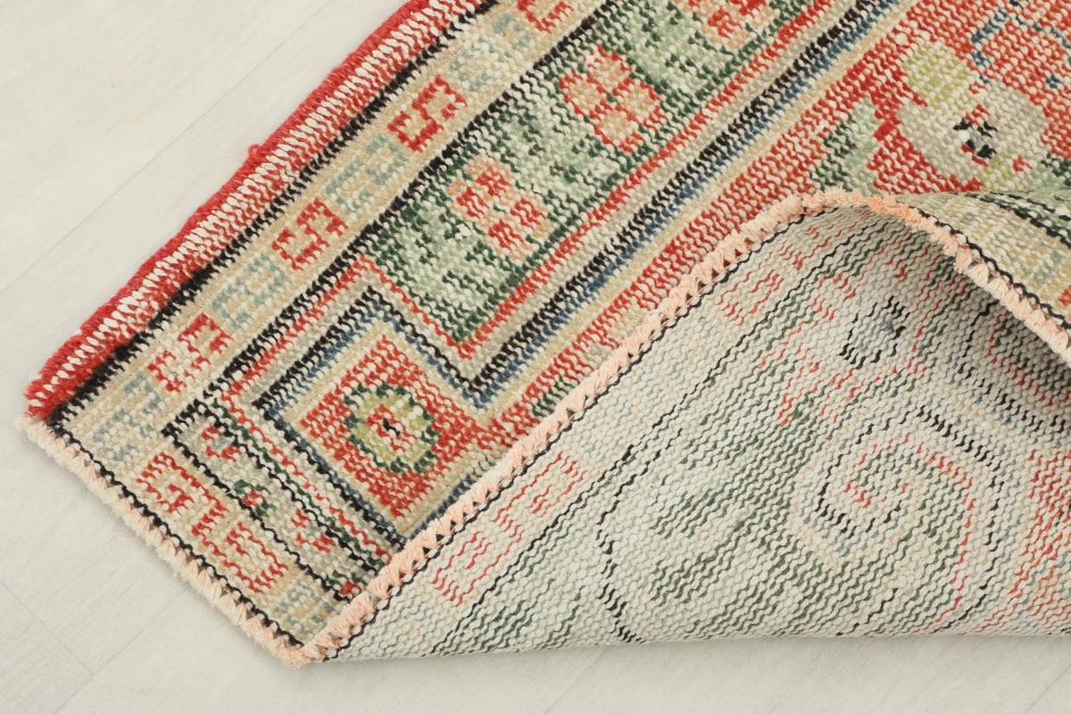 Corner of the rug folded to show the hand-knotted cotton foundation and reverse side