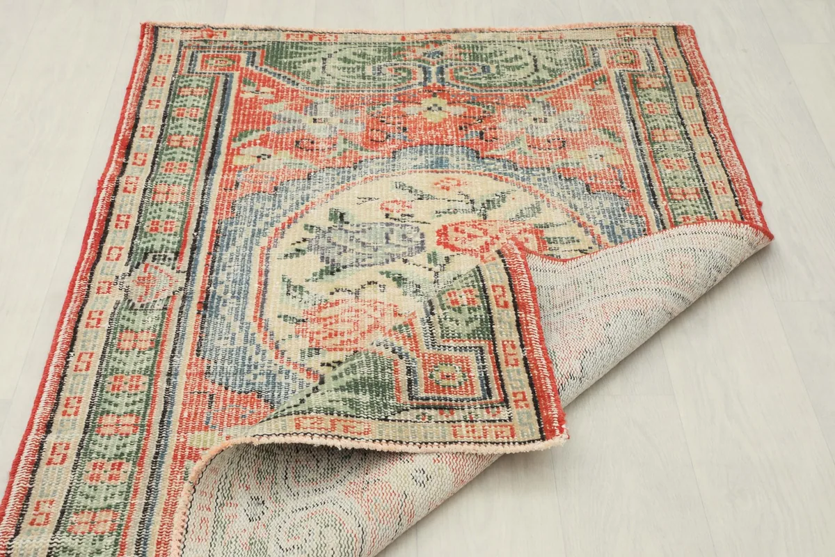 Angled view of the rug with a corner folded over, displaying the backside and full pattern