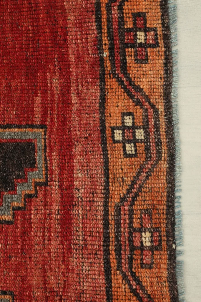 Close-up of the tan border with small geometric motifs and red field