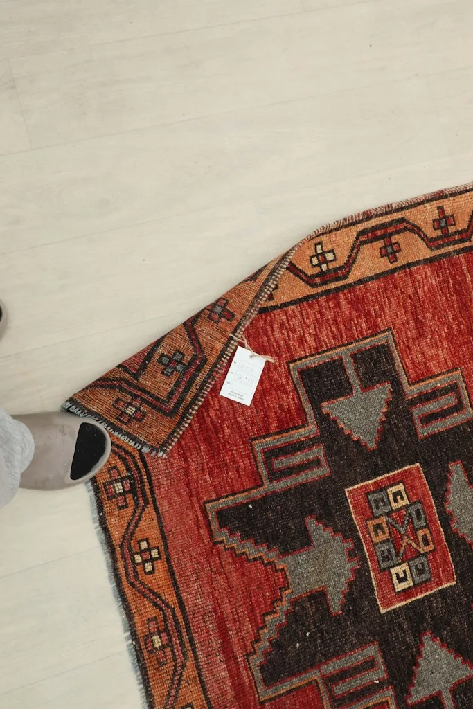 Underside of the rug near the corner, showing the cotton foundation and knotting