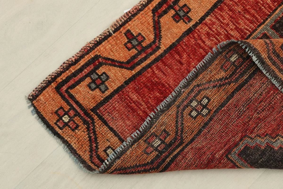 Corner of the runner folded to show the thickness and back of the rug