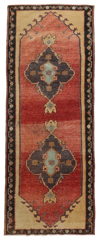 Overhead view of a rust and navy vintage Anatolian runner rug with a medallion pattern