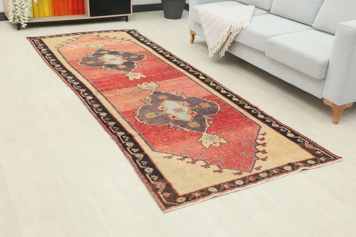 Angled view of the rust and navy runner rug in a room setting, showing its length