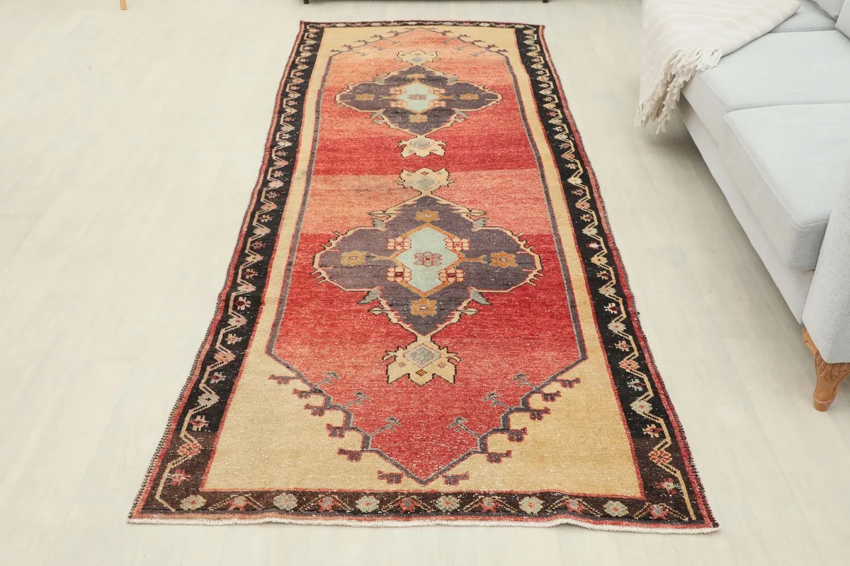 Full length view of the rust and navy runner rug in a room, offering a complete perspective