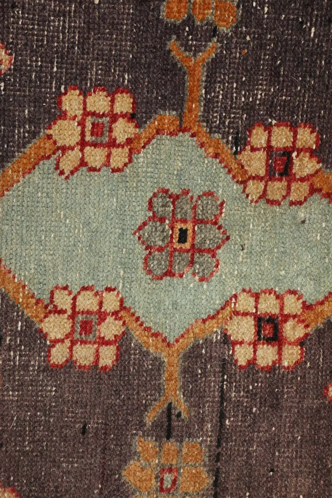 Macro view of the navy medallion, highlighting the detailed blue and gold patterns and wool texture