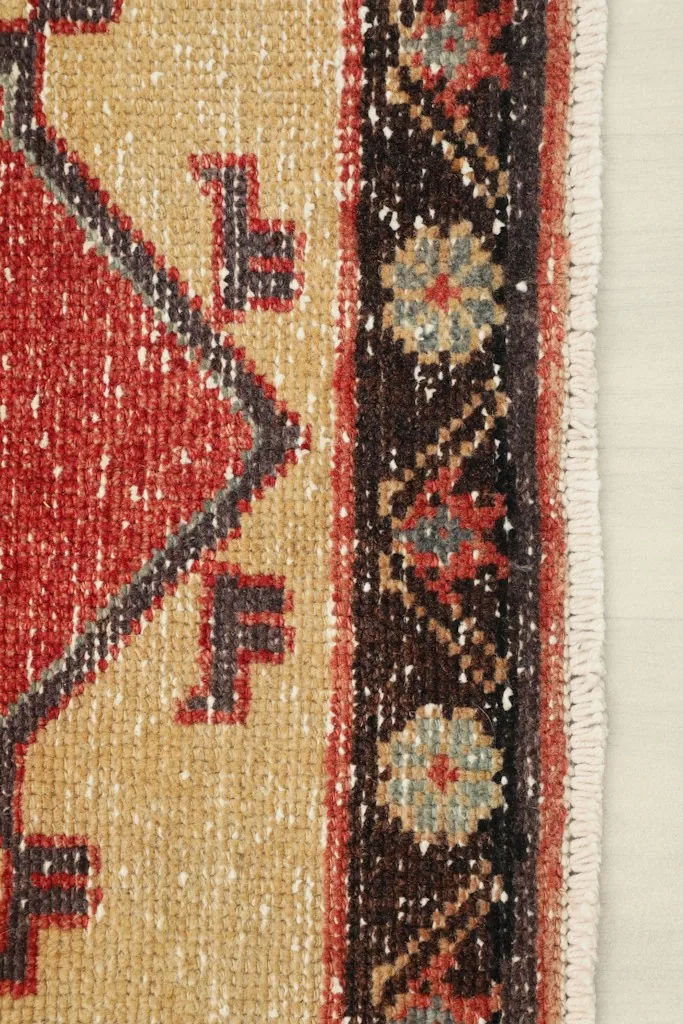 Close-up of the black and tan border, showing the intricate hand-knotted patterns and fringe