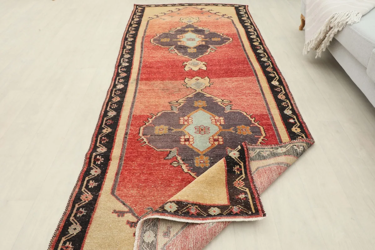 View of the runner rug with a section folded, showcasing the full pattern and construction