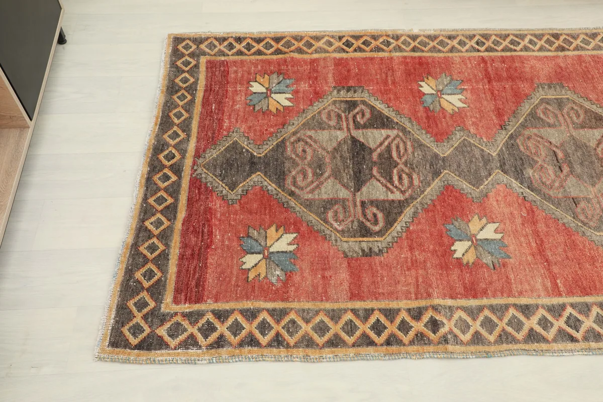 Close-up angled shot of one end of the runner rug, showing the geometric patterns and border.