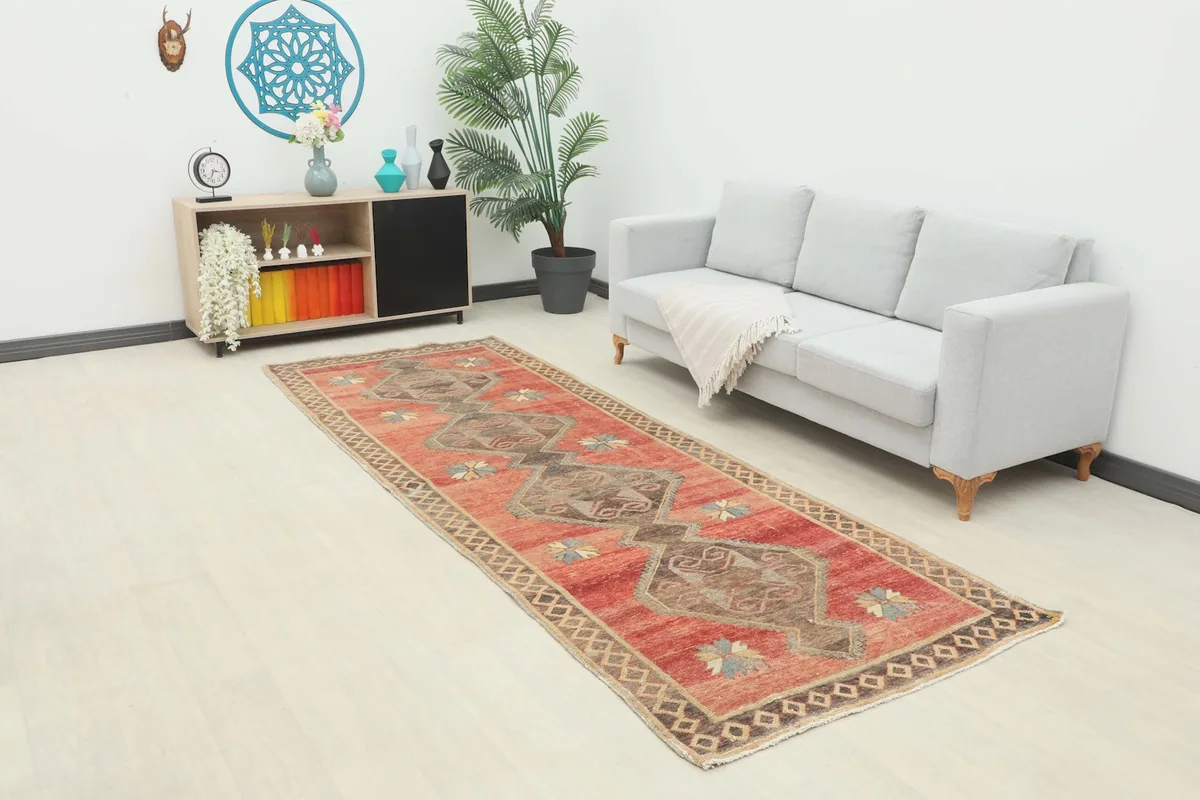 Vintage red runner rug displayed in a modern living room setting with a light sofa.