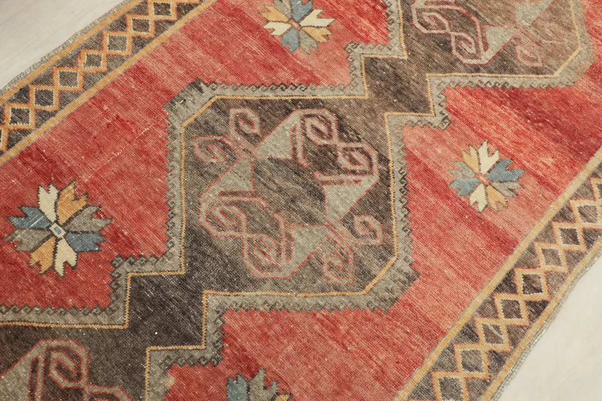 Detailed view of a central geometric medallion with brown, gray, and red colors.