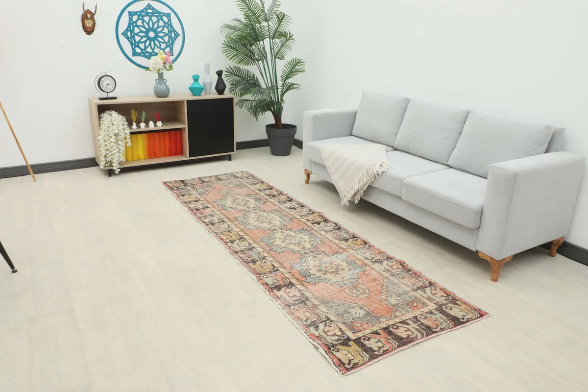 Vintage rust runner rug displayed in a modern living room setting next to a gray sofa