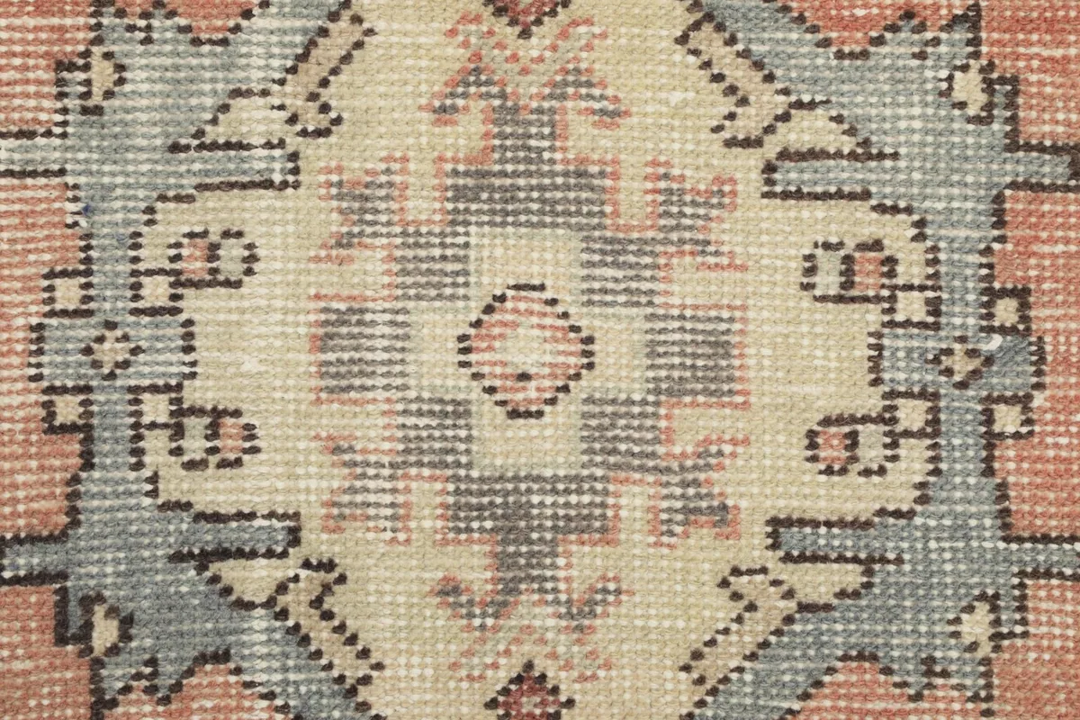 Close-up of the intricately knotted central motif showing color variations and texture